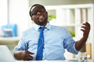 Image of young businessman taking pleasure in his favourite music in office